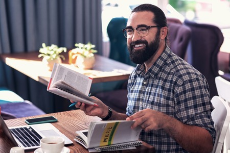 Student coming. Beaming foreign language tutor smiling while seeing his student coming for the classの写真素材