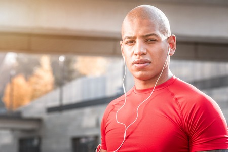 My music. Portrait of a nice young man wearing headphones while looking at you