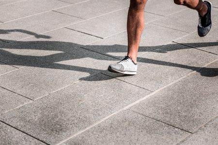 Fast and furious. Legs of a strong afro American man while running very fastの写真素材