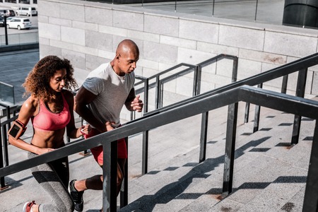 Our workout. Nice sportive people running up the stairs while having a workout togetherの写真素材