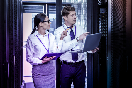 Information safety. Professional positive colleagues standing together while discussing modern...