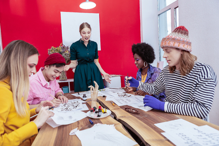 Creative students. Four creative fashionable students of fashion department listening to teacherの写真素材