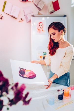 Paper with painting. Beautiful stylish promising artist holding paper with nice marble painting