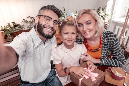 Love and happiness. Delighted united family smiling while posing for a photo togetherの写真素材