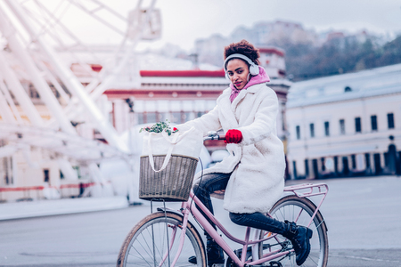 Open-air activity. Cheerful afro woman keeping smile on her face while looking straight at cameraの写真素材