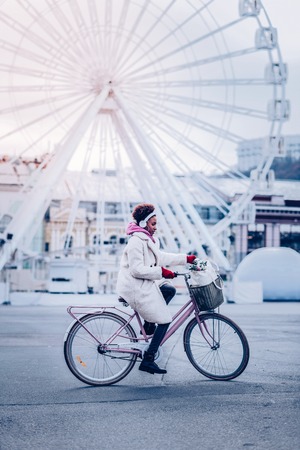 Autumn weather. Cute international girl wearing headphones while enjoying daytime walkの写真素材