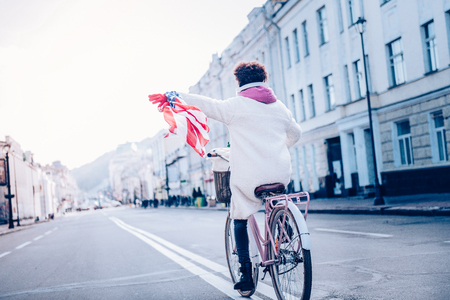 Group leader. Delighted female riding bicycle while enjoying city viewsの写真素材