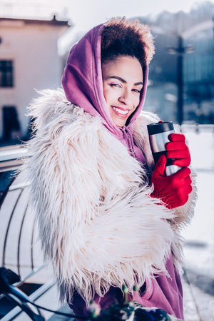 Colorful mood. Amazing female looking at camera while standing near her bicycleの写真素材