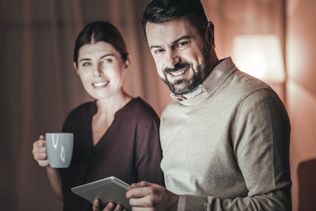 Business correspondence. Happy two colleagues working at night and using tabletの写真素材