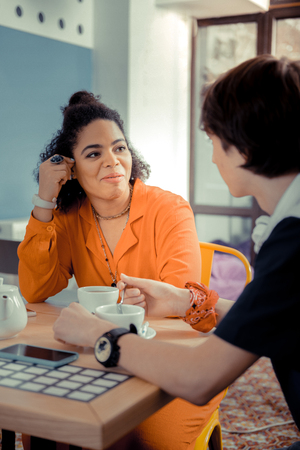 Meeting old friends. Teenagers having an interesting conversation while drinking tea in cafeの写真素材