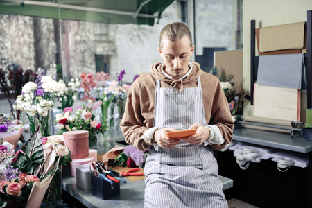 Time to rest. Kind florist being at his workplace and waiting for his clientの写真素材