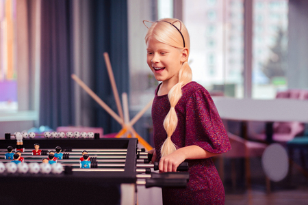 Happy childhood. Nice kid with blond hair breaking stereotypes, competing with her friendsの写真素材