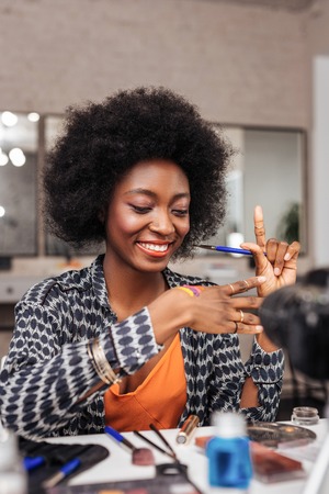 Feeling great. Beautiful dark-skinned african american woman feeling happy while trying new bright...