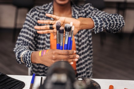 Collection of brushes. African american woman wearing a trendy shirt feeling amazing while...