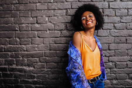 Photo session. Adorable african american model smiling pleasantly while posing for the photoの写真素材