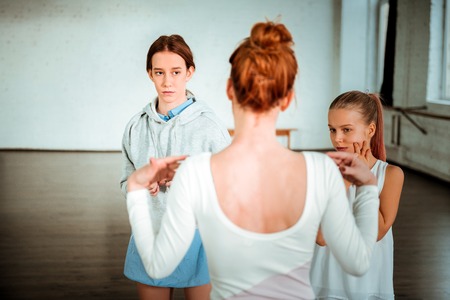 At the ballet school. Professional modern dance teacher with red hair wearing white sport clothing...