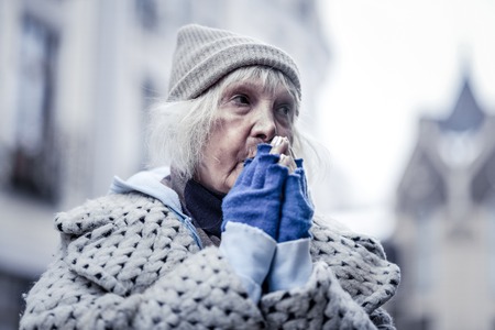 Cold winter. Unhappy poor woman feeling very cold while being outside in winterの写真素材