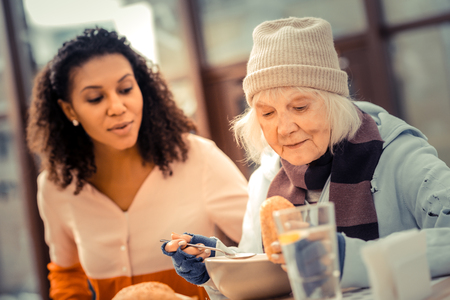 Constant hunger. Nice senior woman looking at the food while having lunch in the cafeの写真素材