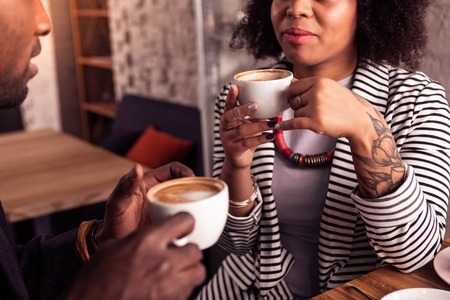 On a date. Nice pleasant couple drinking coffee together while being in the cafeの写真素材