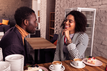 Pleasant conversation. Joyful positive couple talking to each other while having coffeeの写真素材