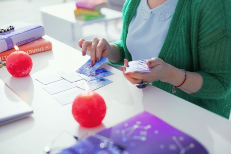 Tarot cards in fortune telling. Top view of tarot cards being put on the table while a professional fortune tellerの写真素材
