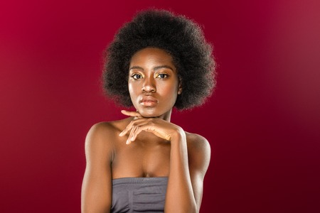 Beautiful woman. Beautiful young woman touching her chin while looking at you