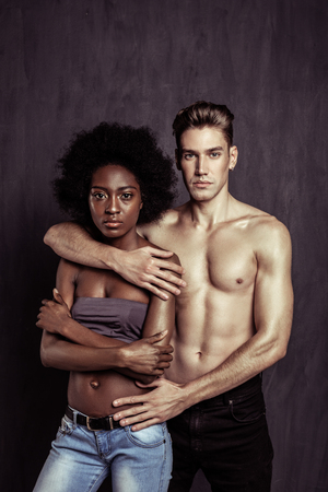 Visible contrast. Beautiful young people looking at you while posing for a photo togetherの写真素材