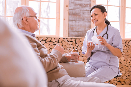 Time to relax. Charming brunette woman working in nursing home and giving psychological supportの写真素材