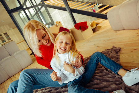 Feeling happiness. Delighted woman expressing positivity while embracing her childの写真素材