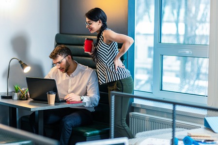 Want to see. Concentrated bearded male person staring at screen of his computer and working at his projectの写真素材
