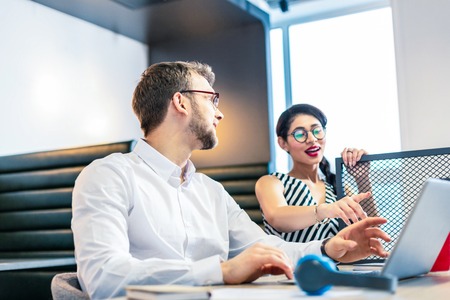 Wait a moment. Handsome male person turning head while listening to his partnerの写真素材