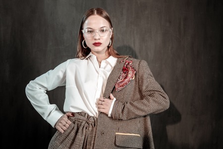 Fashion industry. Beautiful model looking straight at camera and putting right hand on waist
