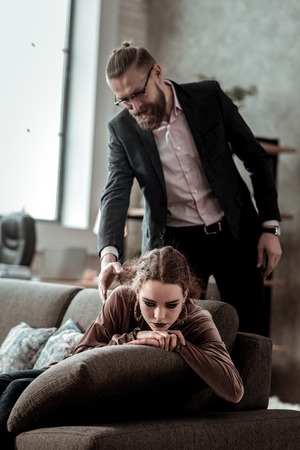 Depressed daughter. Businessman coming home and seeing his daughter feeling depressed and lonelyの写真素材