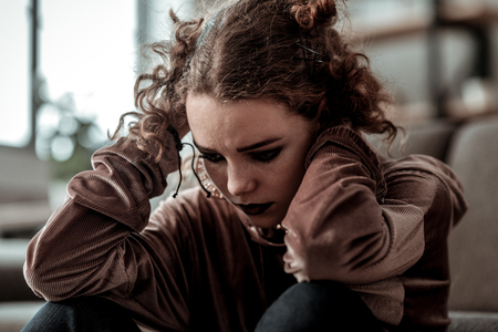Curly teenage girl. Close up of curly teenage girl with dark makeup feeling bad after divorce of parentsの写真素材