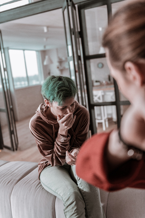 Having crazy man. Young green-haired wife crying badly while feeling helpless having crazy manの写真素材