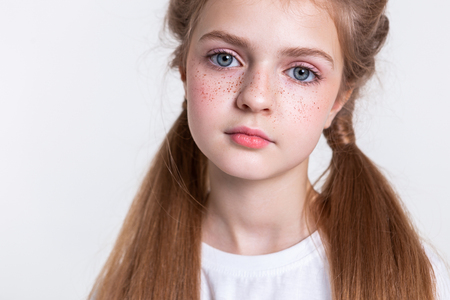 Girl being sad. Peaceful calm good-looking lady with long healthy hair showing her round face with bright frecklesの写真素材