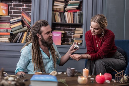 Be careful. Nice pleasant man giving special seeds to his visitor while asking her to be careful with themの写真素材