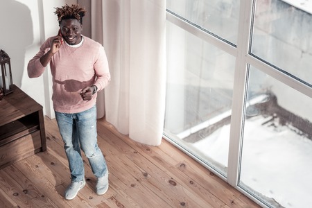 So pleased. Pleased dark-skinned man keeping smile on his face while having finance consultationの写真素材