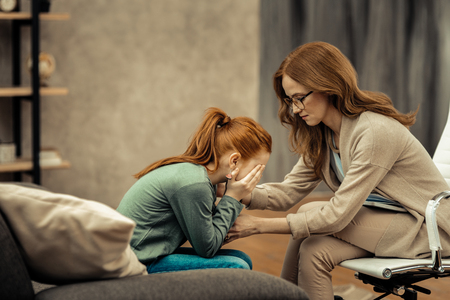 Nervous breakdown. Cheerless depressed girl crying while having big problems in her lifeの写真素材