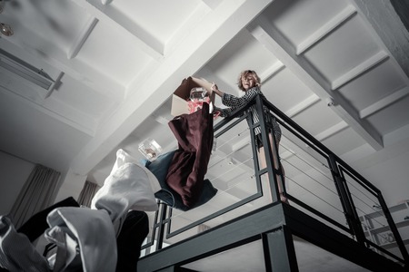 Angry woman. Emotional angry and stressed woman throwing clothes of ex husband awayの写真素材