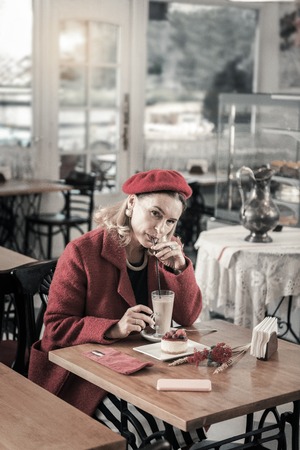 Female power. Kind woman sitting in cafe while enjoying hot chocolateの写真素材