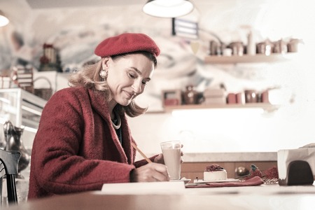 Natural beauty. Amazing lady sitting in semi position and looking downwards at copybookの写真素材