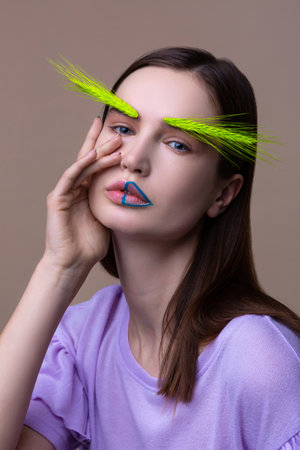 Spikelet and lines. Blue-eyed young promising model with blue lines in lips posing with spikeletの写真素材