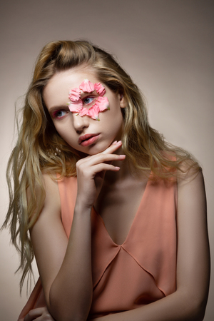 Wearing nice dress. Appealing good-looking model wearing nice light pink dress posing near backgroundの写真素材