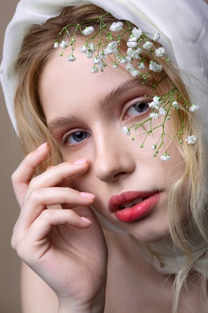 Decorations on head. Blue-eyed young blonde-haired model posing with decorations on her headの写真素材