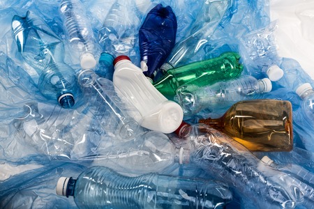 Chaotic order. Colorful crumpled wasted bottles lying in a pile and cluttering environment