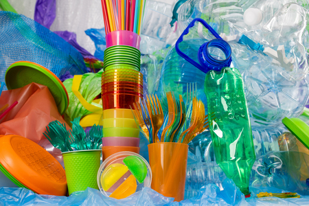 Showing state. Transparent plastic forks standing in bright cup with funky straws nearby as a part of anti-plastic campaignの写真素材