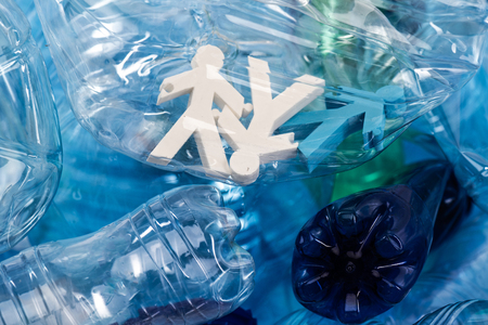 Unprocessed plastic garbage. Colorful figures of people placed inside of plastic bottle as victims...