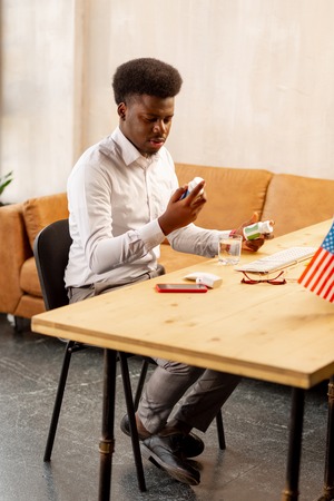 Will it help. Nice African American man looking at the pills while being in the office