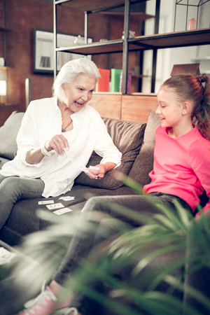 Having much fun. Granny and girl having much fun while doing homework together at the weekendの写真素材